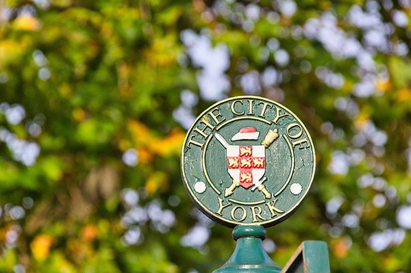 York's coat of arms with trees in the background
